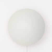 Poul Henningsenがデザインし、Louis Poulsen社から発表されたウォールランプ「PH ハット」直径30cmです。スチール製の半円形シェードは内側を淡いピンク色に仕上げ、点灯時には柔らかで温かみのある光を壁面に広げます。シンプルながら緻密に計算された光の効果はヘニングセンならではの魅力で、寝室や廊下、リビングの補助照明として最適です。1950年代に誕生したモデルは現在でも高く評価されており、ビンテージならではの風合いと希少性を備えています。元々は2サイズ展開で、本品は現行品には存在しない大サイズの希少モデルです。