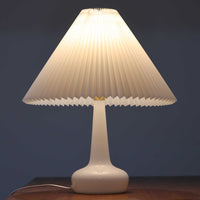 Esben KlintがLe Klintのためにデザインした「Model 311」テーブルランプです。高さ48cmの程よいサイズ感で、ガラスベースと真鍮パーツの組み合わせが美しい一品で、ベース部分はオリジナルです。シェードは後年に交換されたもので、LE KLINT社製のオリジナルではございませんが、同様にプラスチックシートを用いて製作されており、雰囲気を損なうことなく調和しています。点灯時には柔らかな光が広がり、落ち着いた雰囲気を演出。シンプルながらも存在感のあるデザインは、リビングやベッドサイドのアクセントとして最適です。デンマークデザインの伝統と職人技が息づくビンテージ照明です。