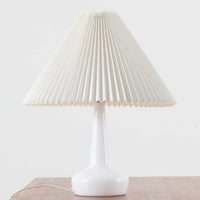 Esben KlintがLe Klintのためにデザインした「Model 311」テーブルランプです。高さ48cmの程よいサイズ感で、ガラスベースと真鍮パーツの組み合わせが美しい一品で、ベース部分はオリジナルです。シェードは後年に交換されたもので、LE KLINT社製のオリジナルではございませんが、同様にプラスチックシートを用いて製作されており、雰囲気を損なうことなく調和しています。点灯時には柔らかな光が広がり、落ち着いた雰囲気を演出。シンプルながらも存在感のあるデザインは、リビングやベッドサイドのアクセントとして最適です。デンマークデザインの伝統と職人技が息づくビンテージ照明です。