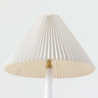 Esben KlintがLe Klintのためにデザインした「Model 311」テーブルランプです。高さ48cmの程よいサイズ感で、ガラスベースと真鍮パーツの組み合わせが美しい一品で、ベース部分はオリジナルです。シェードは後年に交換されたもので、LE KLINT社製のオリジナルではございませんが、同様にプラスチックシートを用いて製作されており、雰囲気を損なうことなく調和しています。点灯時には柔らかな光が広がり、落ち着いた雰囲気を演出。シンプルながらも存在感のあるデザインは、リビングやベッドサイドのアクセントとして最適です。デンマークデザインの伝統と職人技が息づくビンテージ照明です。