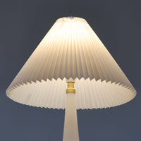 Esben KlintがLe Klintのためにデザインした「Model 311」テーブルランプです。高さ48cmの程よいサイズ感で、ガラスベースと真鍮パーツの組み合わせが美しい一品で、ベース部分はオリジナルです。シェードは後年に交換されたもので、LE KLINT社製のオリジナルではございませんが、同様にプラスチックシートを用いて製作されており、雰囲気を損なうことなく調和しています。点灯時には柔らかな光が広がり、落ち着いた雰囲気を演出。シンプルながらも存在感のあるデザインは、リビングやベッドサイドのアクセントとして最適です。デンマークデザインの伝統と職人技が息づくビンテージ照明です。