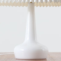 Esben KlintがLe Klintのためにデザインした「Model 311」テーブルランプです。高さ48cmの程よいサイズ感で、ガラスベースと真鍮パーツの組み合わせが美しい一品で、ベース部分はオリジナルです。シェードは後年に交換されたもので、LE KLINT社製のオリジナルではございませんが、同様にプラスチックシートを用いて製作されており、雰囲気を損なうことなく調和しています。点灯時には柔らかな光が広がり、落ち着いた雰囲気を演出。シンプルながらも存在感のあるデザインは、リビングやベッドサイドのアクセントとして最適です。デンマークデザインの伝統と職人技が息づくビンテージ照明です。