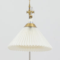 Esben Klintによるデザインで、Le Klint(レ・クリント)より発表されたテーブルランプModel 319です。真鍮とスチールを組み合わせた構造は、堅牢さと洗練された印象を兼ね備え、ハンドメイドのプリーツシェードが柔らかい光を拡散します。高さ75cmの程よいサイズ感とクロスバー構造による可動性が特徴で、デスクやリビングでの読書灯としても実用的です。経年による真鍮の風合いがビンテージらしい魅力を引き立て、空間にクラシカルで上質な雰囲気をもたらします。