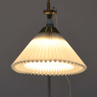 Esben Klintによるデザインで、Le Klint(レ・クリント)より発表されたテーブルランプModel 319です。真鍮とスチールを組み合わせた構造は、堅牢さと洗練された印象を兼ね備え、ハンドメイドのプリーツシェードが柔らかい光を拡散します。高さ75cmの程よいサイズ感とクロスバー構造による可動性が特徴で、デスクやリビングでの読書灯としても実用的です。経年による真鍮の風合いがビンテージらしい魅力を引き立て、空間にクラシカルで上質な雰囲気をもたらします。