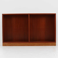 Borge Mogensen(ボーエ・モーエンセン)によるFDB社製のブックシェルフです。チーク材とオーク材を組み合わせた構造で、温かみのある色合いと堅牢な造りが魅力です。幅122cmのワイドなサイズで、書籍や雑誌の収納はもちろん、オブジェやコレクションのディスプレイにも適しています。シンプルで直線的なフォルムは北欧家具らしい機能美を感じさせ、経年によって増した深い色艶がビンテージならではの存在感を放ちます。書斎やリビングにおいて実用性と美観を兼ね備えた一台です。