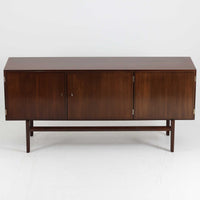 Ole Wanscher(オーレ・ヴァンシャー)がデザインし、P.Jeppesen社より製造された「Rungstedlund」キャビネットです。端正な直線構成と細く伸びた脚部が特徴で、マホガニー材特有の深い色調と気品ある木目が空間に落ち着きをもたらします。内部は棚板とトレイが効率よく配置され、食器から書類収納まで幅広く活用可能。上質な素材使いと精巧な造り込みはヴァンシャー作品ならではで、経年により全体に落ち着いた色調へと変化しており、現地デンマークのオークションで入手した確かな出自を持つ個体です。