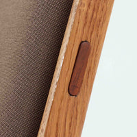 Hans J. Wegner(ハンス・J・ウェグナー)によるイージーチェア「AP16」。デンマークの名門AP stolen社より製造された一脚です。緩やかに傾斜した背もたれと、滑らかに削り出されたアームの曲線が美しく調和し、オーク材の力強い木目と職人技が際立ちます。背面にはブラウン、座面にはグリーンストライプの張地を採用し、上品ながらも温かみのある印象を与えます。現地デンマークのオークションで入手した確かな出自を持つ本品は、読書やくつろぎの時間をより豊かなものにしてくれます。経年による木部の風合いがさらに深みを加えています。