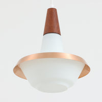 デンマーク製のペンダントライト、直径25cmです。ガラスシェードにチーク材とアルミのパーツを組み合わせた構造は、素材の質感を引き立てながら温かみのある北欧らしいデザインを感じさせます。ガラス越しに広がる柔らかな光は空間を優しく照らし、ダイニングやリビングの照明として心地よい雰囲気を演出します。経年によって深みを増したチーク材や金属部分の風合いはビンテージ品ならではの魅力であり、現行品にはない独自の存在感を楽しめる逸品です。