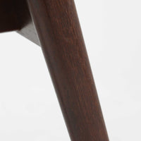 デンマークのデザイナー、Kai Kristiansen(カイ・クリスチャンセン)による「コンパスチェア」。SVA Mobler社より製造された代表作のひとつです。名の通りコンパスの脚を思わせる美しい角度を持つフレーム構造が特徴で、木部にはステイン塗装された濃い色味のオーク材が使用されています。背もたれからアームへと流れるようなラインが柔らかく、身体を包み込むような快適な座り心地を実現。落ち着いたグレーの張地が空間に馴染みます。北欧デザインの美と機能が融合した名作チェアです。