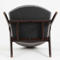 デンマークのデザイナー、Kai Kristiansen(カイ・クリスチャンセン)による「コンパスチェア」。SVA Mobler社より製造された代表作のひとつです。名の通りコンパスの脚を思わせる美しい角度を持つフレーム構造が特徴で、木部にはステイン塗装された濃い色味のオーク材が使用されています。背もたれからアームへと流れるようなラインが柔らかく、身体を包み込むような快適な座り心地を実現。落ち着いたグレーの張地が空間に馴染みます。北欧デザインの美と機能が融合した名作チェアです。