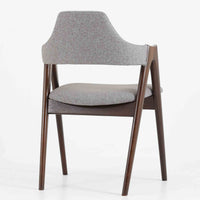 デンマークのデザイナー、Kai Kristiansen(カイ・クリスチャンセン)による「コンパスチェア」。SVA Mobler社より製造された代表作のひとつです。名の通りコンパスの脚を思わせる美しい角度を持つフレーム構造が特徴で、木部にはステイン塗装された濃い色味のオーク材が使用されています。背もたれからアームへと流れるようなラインが柔らかく、身体を包み込むような快適な座り心地を実現。落ち着いたグレーの張地が空間に馴染みます。北欧デザインの美と機能が融合した名作チェアです。