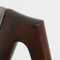 デンマークのデザイナー、Kai Kristiansen(カイ・クリスチャンセン)による「コンパスチェア」。SVA Mobler社より製造された代表作のひとつです。名の通りコンパスの脚を思わせる美しい角度を持つフレーム構造が特徴で、木部にはステイン塗装された濃い色味のオーク材が使用されています。背もたれからアームへと流れるようなラインが柔らかく、身体を包み込むような快適な座り心地を実現。落ち着いたグレーの張地が空間に馴染みます。北欧デザインの美と機能が融合した名作チェアです。