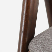 デンマークのデザイナー、Kai Kristiansen(カイ・クリスチャンセン)による「コンパスチェア」。SVA Mobler社より製造された代表作のひとつです。名の通りコンパスの脚を思わせる美しい角度を持つフレーム構造が特徴で、木部にはステイン塗装された濃い色味のオーク材が使用されています。背もたれからアームへと流れるようなラインが柔らかく、身体を包み込むような快適な座り心地を実現。落ち着いたグレーの張地が空間に馴染みます。北欧デザインの美と機能が融合した名作チェアです。