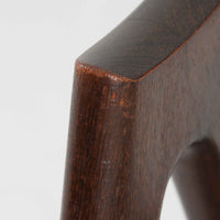 デンマークのデザイナー、Kai Kristiansen(カイ・クリスチャンセン)による「コンパスチェア」。SVA Mobler社より製造された代表作のひとつです。名の通りコンパスの脚を思わせる美しい角度を持つフレーム構造が特徴で、木部にはステイン塗装された濃い色味のオーク材が使用されています。背もたれからアームへと流れるようなラインが柔らかく、身体を包み込むような快適な座り心地を実現。落ち着いたグレーの張地が空間に馴染みます。北欧デザインの美と機能が融合した名作チェアです。