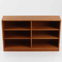 Borge Mogensen(ボーエ・モーエンセン)によるFDB社製のブックシェルフです。良質なオーク材で、温かみのある色合いと堅牢な造りが魅力です。幅122cmのワイドなサイズで、書籍や雑誌の収納はもちろん、オブジェやコレクションのディスプレイにも適しています。シンプルで直線的なフォルムは北欧家具らしい機能美を感じさせ、経年によって増した深い色艶がビンテージならではの存在感を放ちます。書斎やリビングにおいて実用性と美観を兼ね備えた一台です。