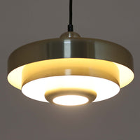 Vitrika社製のペンダントライト「Gogo」です。直径30cmのサイズで、アルミ素材のシェードを段階的に重ねたデザインが特徴的です。光源を巧みに覆い隠しながらも、上下に柔らかく光を広げる構造により、落ち着いた雰囲気を演出します。真鍮のようなゴールド調の質感が高級感を加え、ビンテージならではの風合いと存在感を楽しめます。コンパクトながらも印象的なデザインで、ダイニングや玄関、書斎など多様なシーンに適した照明です。