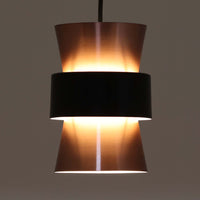 Jo HammerborgがFog & Morup社のためにデザインした直径14cmの小ぶりなペンダントライトです。アルミ製のシェードは上下に広がる砂時計のようなフォルムに、中央のブラックバンドがアクセントとなったモダンなデザイン。点灯時には光が上下にやわらかく広がり、陰影の美しい表情を見せます。コンパクトサイズのためダイニングで複数吊り下げての使用や、玄関・書斎のポイントライトとしても活躍。北欧ビンテージ照明ならではの洗練された存在感を放ちます。