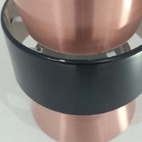 Jo HammerborgがFog & Morup社のためにデザインした直径14cmの小ぶりなペンダントライトです。アルミ製のシェードは上下に広がる砂時計のようなフォルムに、中央のブラックバンドがアクセントとなったモダンなデザイン。点灯時には光が上下にやわらかく広がり、陰影の美しい表情を見せます。コンパクトサイズのためダイニングで複数吊り下げての使用や、玄関・書斎のポイントライトとしても活躍。北欧ビンテージ照明ならではの洗練された存在感を放ちます。