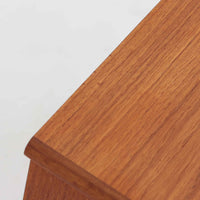 デンマーク製の小ぶりなキャビネットです。チーク材をメインに、オーク材やビーチ材を組み合わせることで、温かみのある色調と軽快な雰囲気を併せ持っています。左側は扉付き収納、右側には3杯の引き出しを備え、実用性とデザイン性を両立。丸みを帯びた取っ手や脚部のテーパーラインが北欧家具らしい柔らかな印象を与えます。幅63cmとコンパクトなサイズで、リビングや寝室、玄関など限られたスペースでも活躍する、ビンテージならではの風合いを持つ一台です。