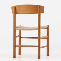 デンマークを代表するデザイナー、Borge MogensenによってFDBのためにデザインされたJ39チェアは、オーク材の丸脚と座面に丁寧に編み込まれたペーパーコードが特徴の、素朴ながらも完成度の高い北欧ビンテージチェアです。農村のキッチンチェアをルーツに持つそのデザインは、無駄を省いた潔い構造と機能美が融合し、空間に凛とした佇まいをもたらします。ダイニングはもちろん、ワークチェアやアクセントチェアとしても重宝する一脚です。