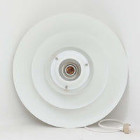 Jeka Metaltryk社製のペンダントライト「1039-H」です。直径41cmと存在感のあるサイズで、スチールを用いた重なり合うシェードが特徴的なデザイン。点灯時には多層のシェードを通して光が柔らかく拡散し、眩しさを抑えつつも温かみのある明かりを広げます。ホワイトカラーのシンプルかつモダンなフォルムは、ダイニングやリビングの主照明として空間に洗練された印象を与えます。北欧ビンテージらしい機能美と存在感を兼ね備えた逸品です。
