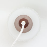 デンマーク製のペンダントライト、直径13cmです。ガラスシェードには立体的なドット模様が施され、点灯すると陰影が浮かび上がり独特の表情を生み出します。上部にはチーク材が用いられ、ガラスの繊細さと木の温もりが調和した北欧らしい意匠が魅力です。小ぶりなサイズながらも存在感があり、キッチンや廊下、ベッドサイドなど複数使いにも適しています。経年による素材の風合いがビンテージ品ならではの味わいを感じさせ、日常空間に個性を添える一品です。