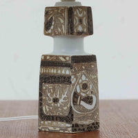 Nils Thorssonがデザインし、Royal Copenhagen社から発表された「BACA」シリーズのテーブルランプは、高さ39cmのバランスの取れたサイズ感で、北欧ビンテージらしい存在感を放ちます。陶磁器製のベースには細やかな装飾模様が施され、グラフィカルでありながら落ち着いた色調が空間に洗練された雰囲気を添えます。リネンシェードを透過する柔らかな光が温もりを演出し、リビングやベッドサイドに最適です。年月を経て深みを増した質感と工芸的な美しさを楽しめる一点物です。