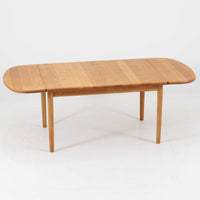 Hans J. Wegnerがデザインし、Getama社より製造されたセンターテーブル「GE82」は、丸脚の意匠が特徴で、四角脚の「GE85」と同時期にデザインされたといわれています。バタフライ構造による拡張機能を備えた北欧ビンテージ家具で、オーク無垢材を贅沢に使用し、幅103cmから160cmへと用途に応じてサイズ調整が可能。普段はコンパクトに、来客時には広々と使える実用性が魅力です。シンプルで力強いフォルムと無垢材ならではの豊かな木目は、年月を経て一層の味わいを増し、空間に温もりと存在感を添えます。