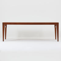 チーク材を用いたデンマーク製の拡張板付きセンターテーブルです。直線的で軽やかなフレーム構造と、脚部から天板へとつながる端正な接合部に北欧ビンテージらしい丁寧なつくりが感じられます。拡張板を引き出すことで天板幅を大きく広げることができ、来客時や作業スペースとしても柔軟に対応します。深みを増したチークの色合いと美しい木目が空間に落ち着きを与え、リビングの主役として長く愛用できる一台です。拡張板はチーク材のほか、黒のラミネート仕上げの2種類が備わっており、用途に応じて使い分けが可能です。ラミネート面は輪染みがつきにくく、作業用や来客時にも気兼ねなく使える実用性を備えています。