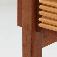 デンマークのサイドチェストです。アフロモシア材の落ち着いた色味の本体に、ビーチ材で成形された横溝装飾の引き出し前板がアクセントとなり、シンプルな構造の中にリズム感のある表情を生み出しています。幅54cmのコンパクトなサイズで、ベッドサイドやソファ脇、玄関先などにも取り入れやすく、引き出し付きで実用性も十分です。経年により深まった木肌の風合いと丁寧なつくりが、北欧ビンテージらしい静かな存在感を空間に添えてくれます。