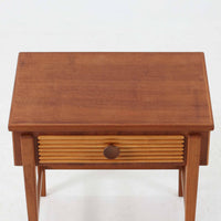 デンマークのサイドチェストです。アフロモシア材の落ち着いた色味の本体に、ビーチ材で成形された横溝装飾の引き出し前板がアクセントとなり、シンプルな構造の中にリズム感のある表情を生み出しています。幅54cmのコンパクトなサイズで、ベッドサイドやソファ脇、玄関先などにも取り入れやすく、引き出し付きで実用性も十分です。経年により深まった木肌の風合いと丁寧なつくりが、北欧ビンテージらしい静かな存在感を空間に添えてくれます。