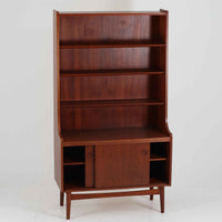 Johannes Sorth(ヨハネス・ソース)によるデザインで、Nexo Mobelfabrik社より製造されたチーク材のディスプレイシェルフです。上部の棚は本やオブジェを美しく飾ることができ、下部には引き戸収納を備え、実用性にも優れています。緩やかな曲線を描く側面のデザインが柔らかな印象を与え、北欧家具らしい温もりと機能美が感じられる一台です。脚部の細身のフォルムが軽やかさを演出し、リビングや書斎、ダイニングなど幅広い空間に調和します。