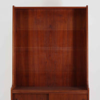 Johannes Sorth(ヨハネス・ソース)によるデザインで、Nexo Mobelfabrik社より製造されたチーク材のディスプレイシェルフです。上部の棚は本やオブジェを美しく飾ることができ、下部には引き戸収納を備え、実用性にも優れています。緩やかな曲線を描く側面のデザインが柔らかな印象を与え、北欧家具らしい温もりと機能美が感じられる一台です。脚部の細身のフォルムが軽やかさを演出し、リビングや書斎、ダイニングなど幅広い空間に調和します。