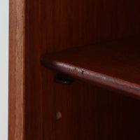 Johannes Sorth(ヨハネス・ソース)によるデザインで、Nexo Mobelfabrik社より製造されたチーク材のディスプレイシェルフです。上部の棚は本やオブジェを美しく飾ることができ、下部には引き戸収納を備え、実用性にも優れています。緩やかな曲線を描く側面のデザインが柔らかな印象を与え、北欧家具らしい温もりと機能美が感じられる一台です。脚部の細身のフォルムが軽やかさを演出し、リビングや書斎、ダイニングなど幅広い空間に調和します。