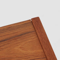 こちらの小ぶりなボードは、温かみのあるチーク材を用いたすっきりとした佇まいが魅力の北欧ビンテージ家具で、スライド扉を開くと左右に棚板付きの収納スペースが現れ、日用品や小物を効率よく整理できます。直線的な箱型の構造に、細身でテーパーの効いた脚部が軽やかな印象を添え、コンパクトながら存在感のある設計が空間に落ち着いたアクセントをもたらします。経年で深まった木肌の質感も味わい深く、リビングや玄関脇のサイド収納としても取り入れやすい一台です。