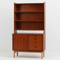 チーク材とオーク材を組み合わせて作られたスウェーデン製のディスプレイシェルフです。幅90cmと使いやすいサイズ感で、上部の棚には本やオブジェを、下部の引き戸と引き出しには日用品を収納できる実用性の高い構成となっています。滑らかな木肌や丁寧な造りには職人技が感じられ、経年により深みを増した木の風合いが空間に温かみをもたらします。リビングやダイニングはもちろん、書斎や寝室の収納兼ディスプレイとしても活躍する、北欧ビンテージ家具らしいシンプルかつ機能的な一台です。