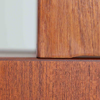 チーク材とオーク材を組み合わせて作られたスウェーデン製のディスプレイシェルフです。幅90cmと使いやすいサイズ感で、上部の棚には本やオブジェを、下部の引き戸と引き出しには日用品を収納できる実用性の高い構成となっています。滑らかな木肌や丁寧な造りには職人技が感じられ、経年により深みを増した木の風合いが空間に温かみをもたらします。リビングやダイニングはもちろん、書斎や寝室の収納兼ディスプレイとしても活躍する、北欧ビンテージ家具らしいシンプルかつ機能的な一台です。