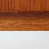 スウェーデン製のチーク材とオーク材を組み合わせたディスプレイシェルフです。幅90cmと程よいサイズ感で、上部の棚は書籍やオブジェの展示に適し、下部の引き戸収納は日用品や小物をすっきりと収めることができます。丸みを帯びた取っ手が温かみのあるアクセントとなり、北欧家具らしいシンプルで実用的なデザインを際立たせています。経年によって深みを増したチークの木目とオークのコントラストが上品な存在感を放ち、リビングや書斎の空間に落ち着いた雰囲気を添えるビンテージ家具です。