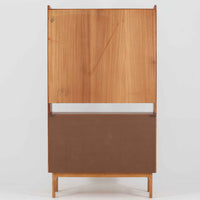 スウェーデン製のチーク材とオーク材を組み合わせたディスプレイシェルフです。幅90cmと程よいサイズ感で、上部の棚は書籍やオブジェの展示に適し、下部の引き戸収納は日用品や小物をすっきりと収めることができます。丸みを帯びた取っ手が温かみのあるアクセントとなり、北欧家具らしいシンプルで実用的なデザインを際立たせています。経年によって深みを増したチークの木目とオークのコントラストが上品な存在感を放ち、リビングや書斎の空間に落ち着いた雰囲気を添えるビンテージ家具です。