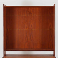 スウェーデン製のチーク材とオーク材を組み合わせたディスプレイシェルフです。幅90cmと程よいサイズ感で、上部の棚は書籍やオブジェの展示に適し、下部の引き戸収納は日用品や小物をすっきりと収めることができます。丸みを帯びた取っ手が温かみのあるアクセントとなり、北欧家具らしいシンプルで実用的なデザインを際立たせています。経年によって深みを増したチークの木目とオークのコントラストが上品な存在感を放ち、リビングや書斎の空間に落ち着いた雰囲気を添えるビンテージ家具です。