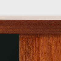 スウェーデン製のチーク材とオーク材を組み合わせたディスプレイシェルフです。幅90cmと程よいサイズ感で、上部の棚は書籍やオブジェの展示に適し、下部の引き戸収納は日用品や小物をすっきりと収めることができます。丸みを帯びた取っ手が温かみのあるアクセントとなり、北欧家具らしいシンプルで実用的なデザインを際立たせています。経年によって深みを増したチークの木目とオークのコントラストが上品な存在感を放ち、リビングや書斎の空間に落ち着いた雰囲気を添えるビンテージ家具です。