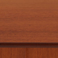 スウェーデン製のディスプレイシェルフです。上段には3段のオープンシェルフが設けられ、本や雑貨、オブジェなどを美しくディスプレイできます。下段にはスライド扉収納が備わり、内部の棚板によって整理しやすく、見せたくない収納にも便利です。チーク材の温もりある木目と、丸い掘り込み取っ手の柔らかなデザインが印象的で、北欧家具らしい穏やかな雰囲気を演出します。背面のグリーンの化粧板が空間に個性を添え、飾るアイテムをより際立たせます。本体にはチーク材、脚部にはオーク材が使用されており、素材のコントラストも魅力のひとつです。下段収納部の棚板にわずかな反りがありますが、裏返して使用することで目立たなくなります。軽やかな佇まいと実用性を兼ね備えた、北欧ビンテージらしい一台です。