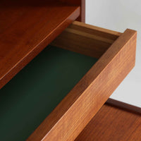 スウェーデン製のディスプレイシェルフです。上部は高さ調整可能な棚板が設けられており、書籍やオブジェの収納・展示に最適です。中央には小引き出しが2杯備わり、カトラリーや小物の整理にも便利。下部には扉付きの収納スペースがあり、日用品をすっきりと収納できます。素材にはチーク(本体)・オーク(脚の幕板)・ビーチ(脚)の3種の木材が用いられ、異なる木目のコントラストが美しい仕上がりです。北欧家具らしい温もりと実用性を兼ね備えた一台で、リビングやダイニング、書斎など幅広いシーンに調和します。