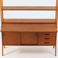 スウェーデン製のディスプレイシェルフで、チーク材とビーチ材の組み合わせが生み出す温かみと軽やかなコントラストが魅力です。上部はオープンな3段棚で開放感があり、お気に入りの雑貨や書籍をすっきりと美しく飾ることができます。下部には引き戸収納と4杯の引き出しを備え、日用品や小物を整理するのにも便利です。幅120cmと取り入れやすいサイズ感で、リビングやダイニングを軽やかに演出。経年による木肌の深みが加わり、シンプルながらも存在感を放つビンテージらしい一台です。