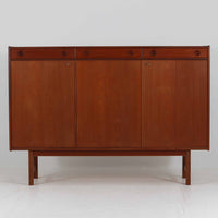 Tage Olofsson(ターゲ・オロフソン)によるデザインで、Ulferts Mobler社製のキッチンキャビネットです。チーク材を贅沢に使用した美しい木目と、丸型の引き手がアクセントとなったデザインが特徴です。上部にはカトラリーなどを整理できる仕切り付きの引き出しが3杯、下部には棚板付きの扉収納が備えられており、食器やキッチン用品を効率的に収納できます。北欧家具らしい温もりと機能性を兼ね備えた一台で、リビングやダイニングにも自然に溶け込む上品な佇まいです。