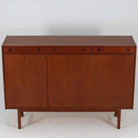 Tage Olofsson(ターゲ・オロフソン)によるデザインで、Ulferts Mobler社製のキッチンキャビネットです。チーク材を贅沢に使用した美しい木目と、丸型の引き手がアクセントとなったデザインが特徴です。上部にはカトラリーなどを整理できる仕切り付きの引き出しが3杯、下部には棚板付きの扉収納が備えられており、食器やキッチン用品を効率的に収納できます。北欧家具らしい温もりと機能性を兼ね備えた一台で、リビングやダイニングにも自然に溶け込む上品な佇まいです。