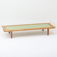 Hans J. Wegner(ハンス・J・ウェグナー)がGetama社のために手掛けたGE19 ベンチソファは、端正なプロポーションと素材使いが際立つ北欧ビンテージの名作です。フレームにはオーク材を用い、細身で安定感のある脚部と、両端に配されたメタルパーツが軽やかなアクセントとなっています。マットレスやクッションを合わせることで、ベンチとしてもベッドとしても幅広く活用可能です。経年により深みを増した木肌と、当時の職人技が感じられる構造が、空間に静かな存在感と上質な佇まいをもたらします。