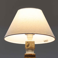 Nils Thorssonがデザインし、Royal Copenhagen社から発表された「BACA」シリーズのテーブルランプは、高さ38cmのバランスの取れたサイズ感で、北欧ビンテージらしい存在感を放ちます。陶磁器製のベースには細やかな装飾模様が施され、グラフィカルでありながら落ち着いた色調が空間に洗練された雰囲気を添えます。リネンシェードを透過する柔らかな光が温もりを演出し、リビングやベッドサイドに最適です。年月を経て深みを増した質感と工芸的な美しさを楽しめる一点物です。