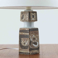 Nils Thorssonがデザインし、Royal Copenhagen社から発表された「BACA」シリーズのテーブルランプは、高さ38cmのバランスの取れたサイズ感で、北欧ビンテージらしい存在感を放ちます。陶磁器製のベースには細やかな装飾模様が施され、グラフィカルでありながら落ち着いた色調が空間に洗練された雰囲気を添えます。リネンシェードを透過する柔らかな光が温もりを演出し、リビングやベッドサイドに最適です。年月を経て深みを増した質感と工芸的な美しさを楽しめる一点物です。