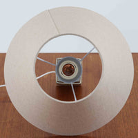 Nils Thorssonがデザインし、Royal Copenhagen社から発表された「BACA」シリーズのテーブルランプは、高さ38cmのバランスの取れたサイズ感で、北欧ビンテージらしい存在感を放ちます。陶磁器製のベースには細やかな装飾模様が施され、グラフィカルでありながら落ち着いた色調が空間に洗練された雰囲気を添えます。リネンシェードを透過する柔らかな光が温もりを演出し、リビングやベッドサイドに最適です。年月を経て深みを増した質感と工芸的な美しさを楽しめる一点物です。